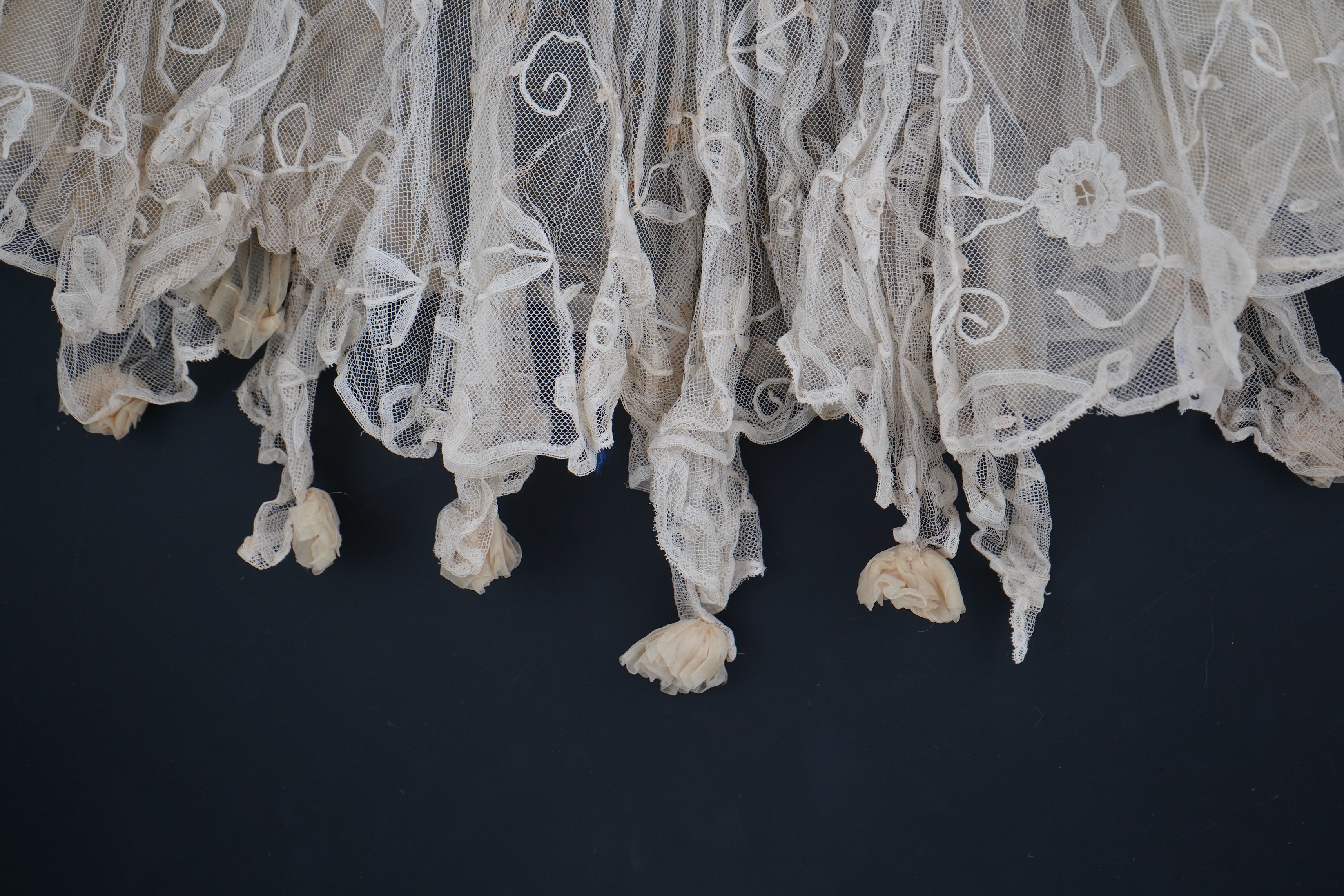 An Edwardian high collared cream tape lace wedding over blouse, made with a deep net frill and cream chiffon rose detail hanging from lower edge, top of collar to rose detail at the front 46cm. Condition - fine silk chif